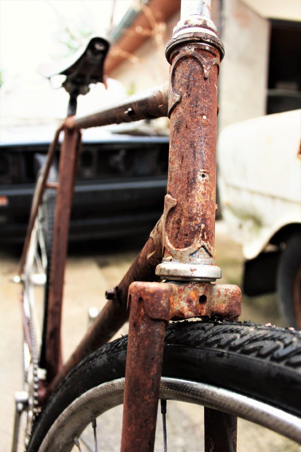 A rusted bicycle body frame without a frame protector.