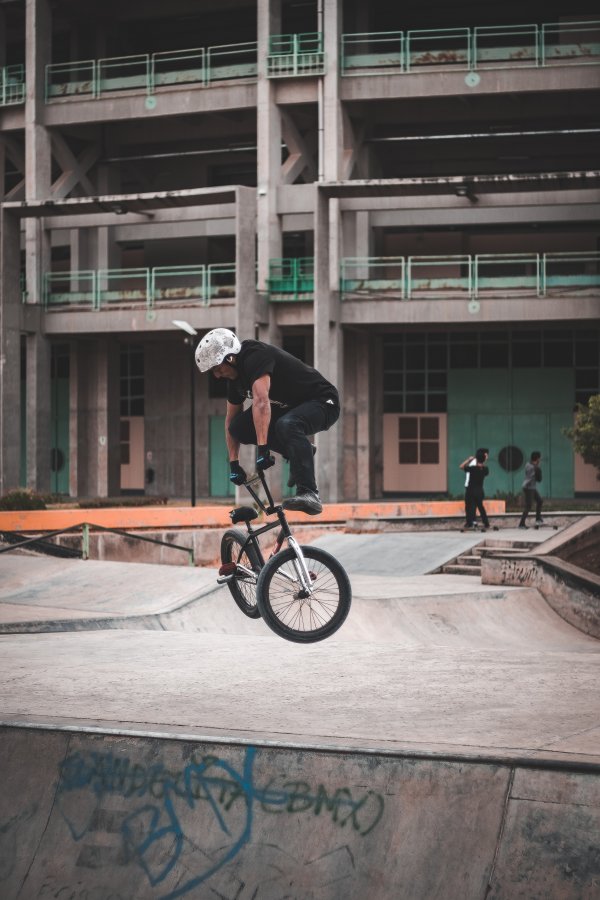 A person wearing a helmet performs a stunt with a bmx bike.