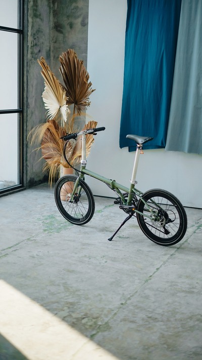 A bike parked in a room, leaning on a kickstand.